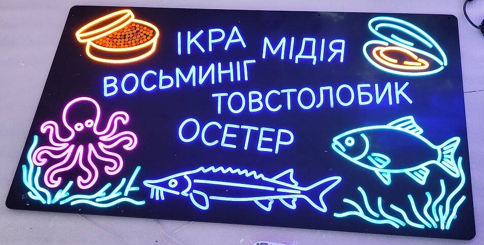 Tweede neonbord voor de viskraam: het assortiment in meerdere kleuren op een zwarte achterplaat, met een octopus, vissen en een schelp